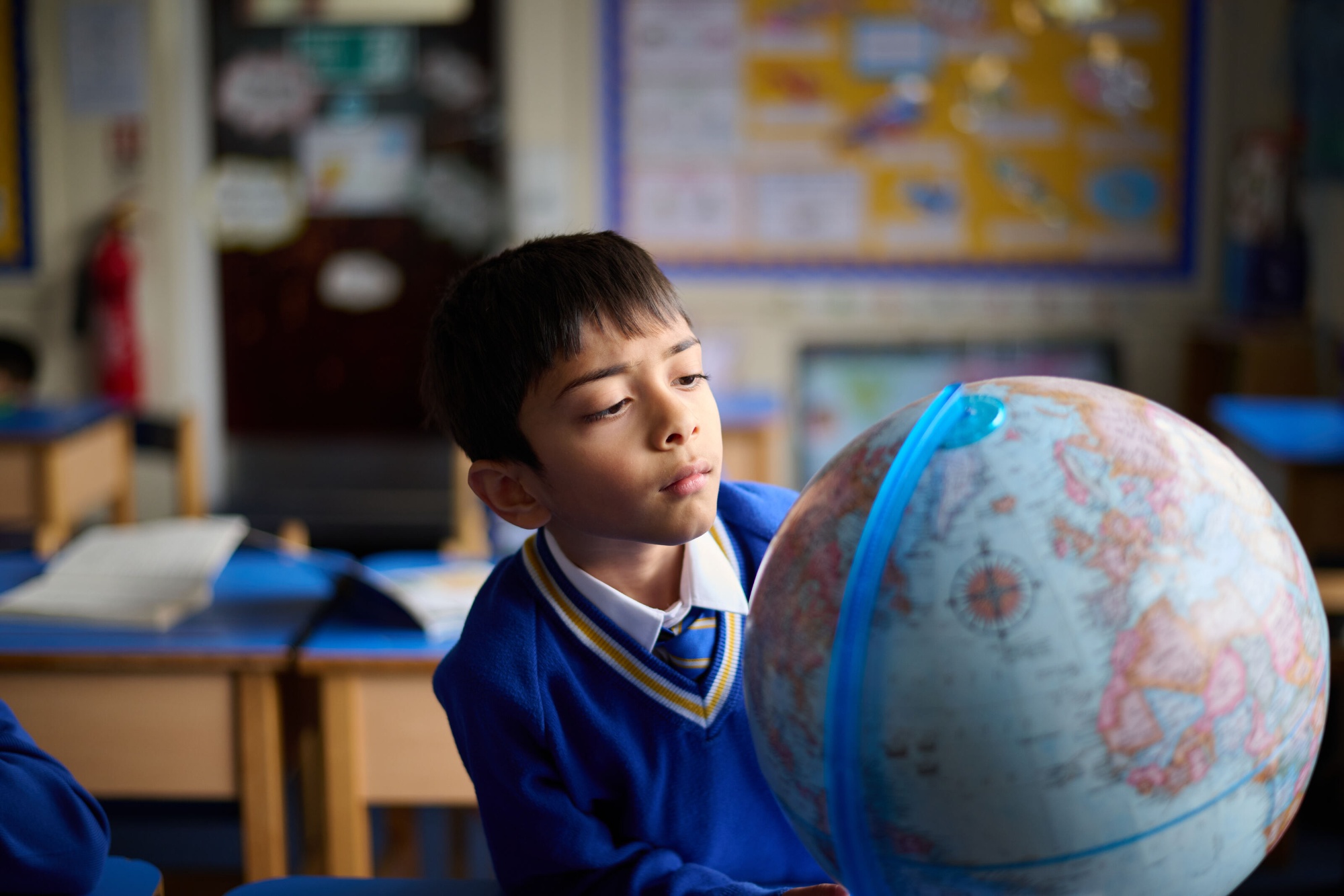 Loyola boy looking at globe